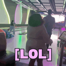 a woman standing in a bowling alley with the word lol written on the floor