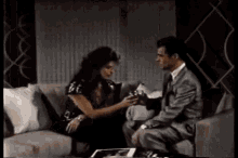 a man and a woman are sitting on a couch .