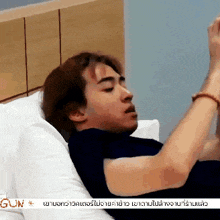 a man is laying on a bed with the word gun on the bottom left