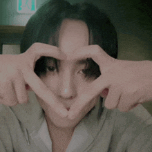 a man making a heart shape with his hands