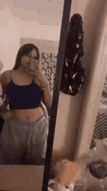 a woman is taking a selfie in a mirror .
