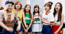 a group of girls are posing for a picture and one of them is wearing a broccoli shirt