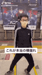 a man wearing a mask is dancing in front of a poster that says tiktok