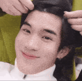 a close up of a person holding a person 's hair while they smile .