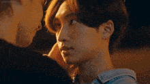 two young men are touching each other 's faces and one of them is wearing earrings .