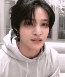 a close up of a person 's face with a hoodie on