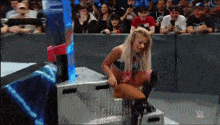 a woman in a wrestling ring with the letter w on the bottom