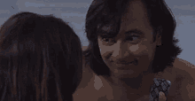 a shirtless man is holding a condom in front of a woman in a pool .