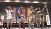 four women are standing in a wrestling ring with a banner that says cosmic angels