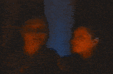a couple of women standing next to each other in a dark room .