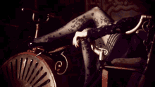 a woman in a black dress sits in a chair