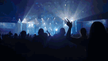 a crowd of people at a concert with their hands up in the air