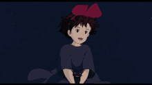 a girl with a red bow is holding a black cat in her hands