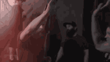 a group of people are dancing in a dark room .
