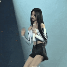 a woman with long black hair is dancing on a stage with a microphone .