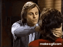 a man is touching a woman 's face in a room .