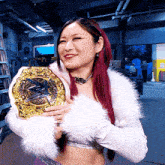 a woman in a white fur coat is holding a gold wrestling championship belt