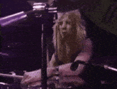 a woman is playing drums in front of a microphone that says ' u ' on it