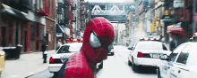 a spider man is standing in the middle of a busy city street