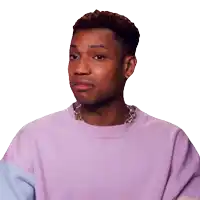 a man wearing a purple sweater and a necklace