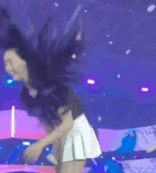 a woman in a white skirt is standing in front of a purple and blue background