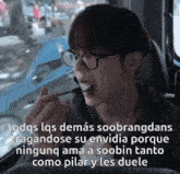a man wearing glasses is eating something with chopsticks