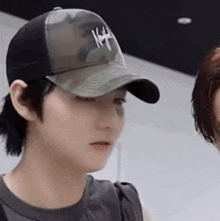 a man wearing a baseball cap is standing next to a woman .