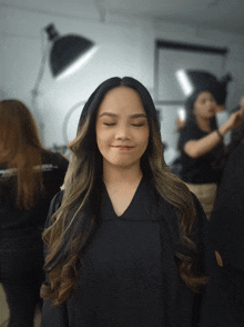 a woman with her eyes closed is wearing a black shirt with the letter a on it