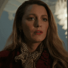 a close up of a woman wearing a scarf and a red jacket