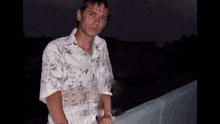 a man in a white shirt is standing on a balcony