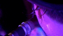 a close up of a person singing into a microphone