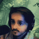 a man with a beard is wearing headphones and a microphone
