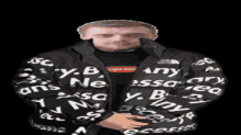 a man wearing a black jacket that says " any " on it