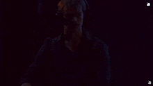 a man in a black shirt is standing in front of a blue light