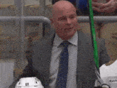 a man in a suit and tie is holding a green stick