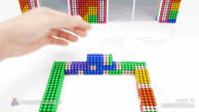 a person is playing with magnetic beads and the words made in animatica are on the bottom
