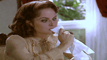 a woman blowing her nose with a napkin