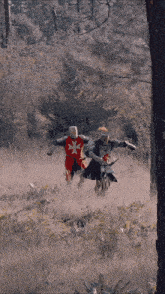 two knights are running through a field and one has a cross on his chest