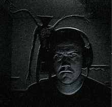 a man wearing headphones has a monster behind him
