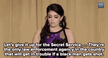a woman in a purple dress is saying let 's give it up for the secret service .