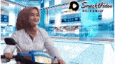 a woman wearing a hijab is riding a scooter in front of a snack video big family logo .