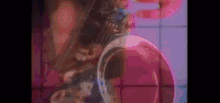 a close up of a person 's face with a purple background and a ring on their finger .