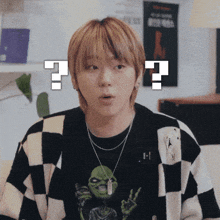 a young man wearing a black and white checkered sweater has a question mark above his head