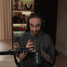 a man wearing headphones sits in front of a mic