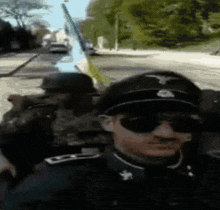 a man in a military uniform is wearing sunglasses and a hat with a eagle on it