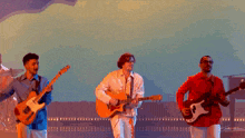 a group of men are playing guitars and singing on stage