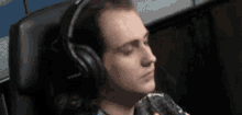 a man wearing headphones is sitting in a chair with a microphone .