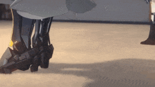a close up of a robot 's legs with a person standing behind them