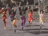 a group of people are jumping in the air while dancing on the street .