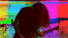 a man with long hair is playing a guitar in front of a rainbow background